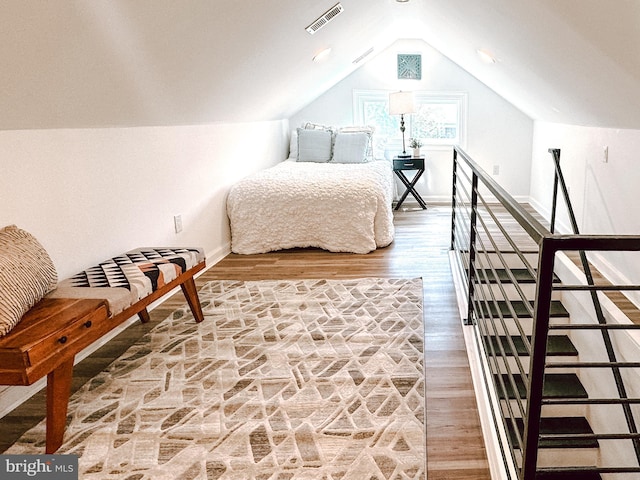 bedroom featuring visible vents, baseboards, vaulted ceiling, and light wood-style floors
