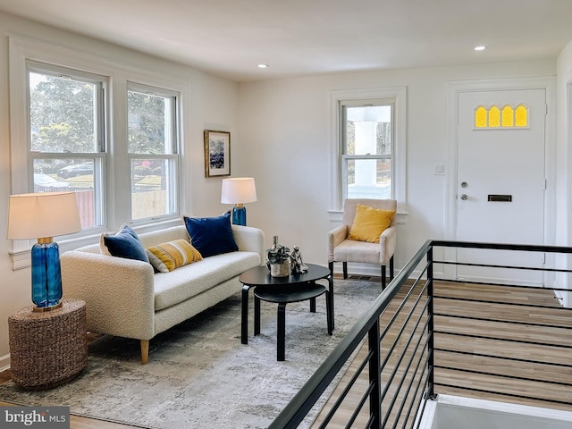 living area featuring recessed lighting, wood finished floors, a healthy amount of sunlight, and stairway