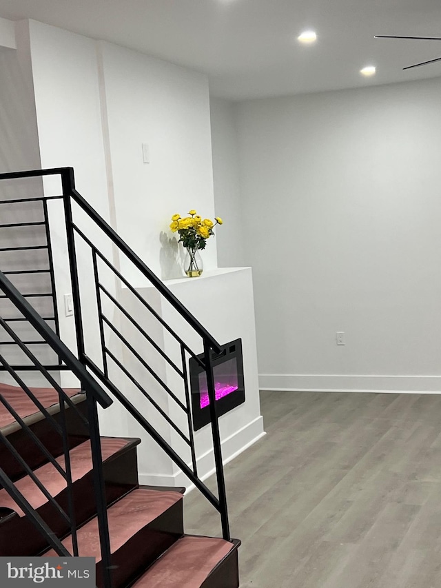 stairway with baseboards, recessed lighting, and wood finished floors