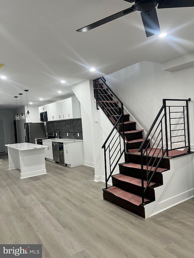 staircase with baseboards, a ceiling fan, recessed lighting, and wood finished floors