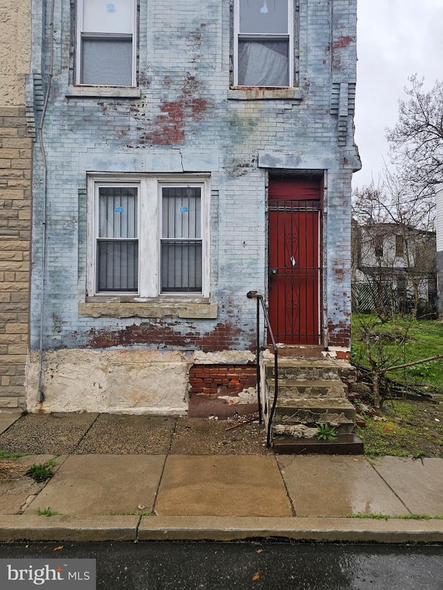 view of exterior entry featuring brick siding