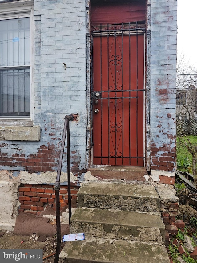 doorway to property featuring brick siding