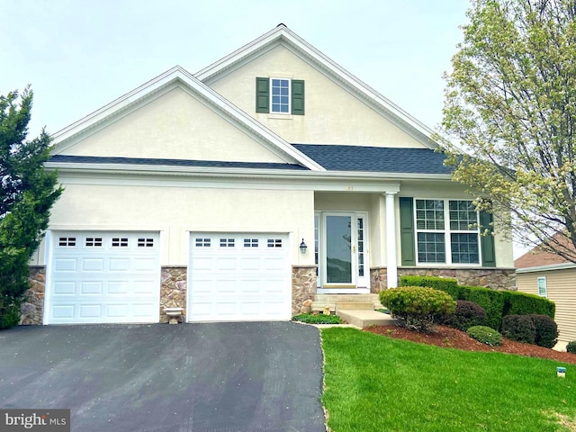 craftsman-style home with aphalt driveway, a front lawn, stucco siding, an attached garage, and stone siding