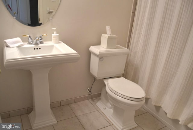 full bathroom with tile patterned flooring, toilet, baseboards, and a sink