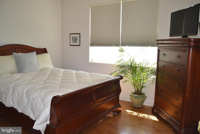 bedroom with baseboards and wood finished floors