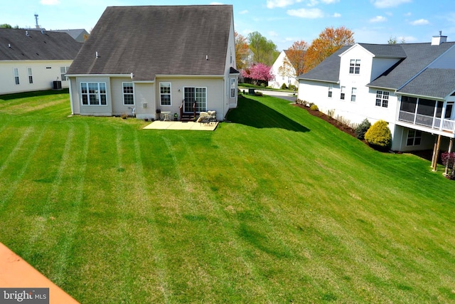 back of property with a lawn and a patio