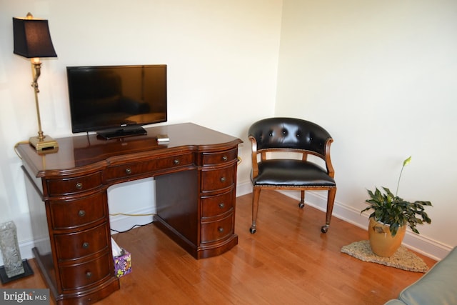 office space with baseboards and wood finished floors