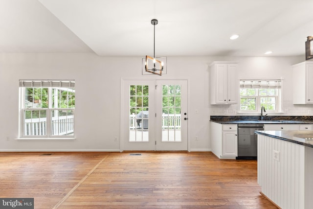 kitchen with dishwasher, light wood-style floors, white cabinets, a chandelier, and baseboards