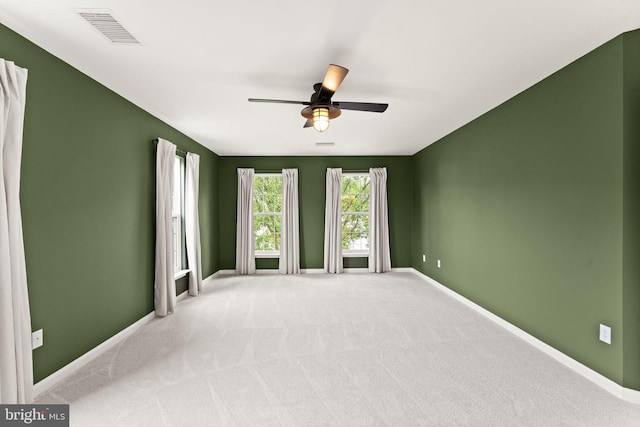 carpeted empty room featuring ceiling fan and baseboards