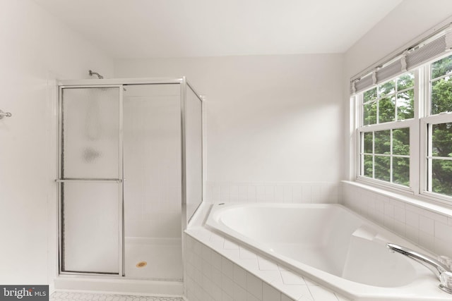 full bathroom featuring a shower stall and a bath
