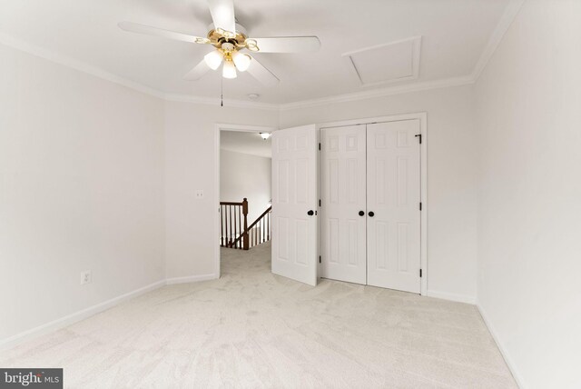 unfurnished bedroom featuring carpet, ornamental molding, baseboards, and a closet