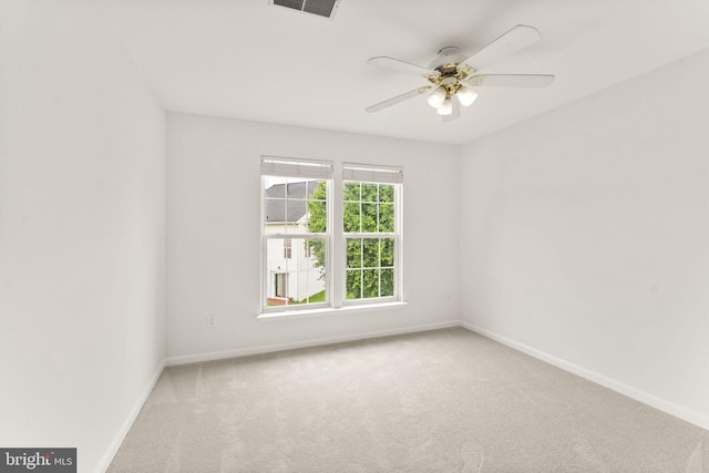 carpeted spare room with baseboards and a ceiling fan