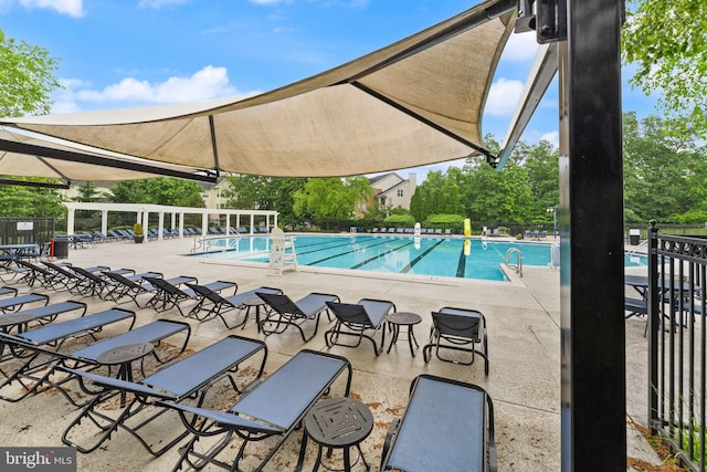 community pool featuring fence and a patio area