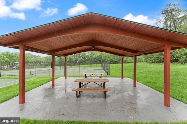 surrounding community featuring a tennis court