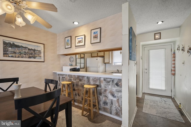 dining room with ceiling fan, baseboards, a textured ceiling, and recessed lighting