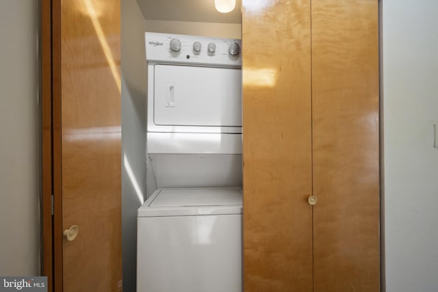 laundry room featuring stacked washer / dryer and laundry area