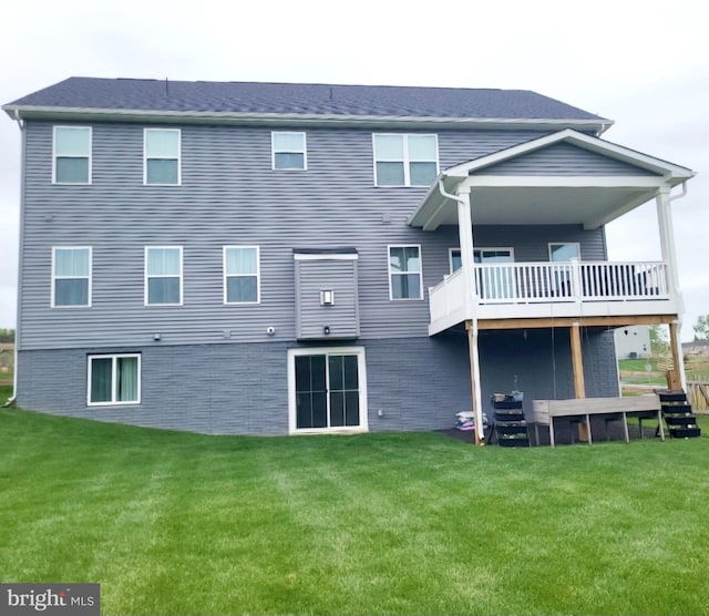 back of house featuring a lawn and a deck