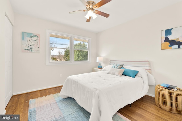 bedroom featuring baseboards, ceiling fan, and wood finished floors