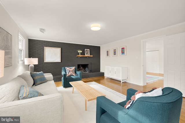 living room with visible vents, ornamental molding, wood finished floors, and a fireplace
