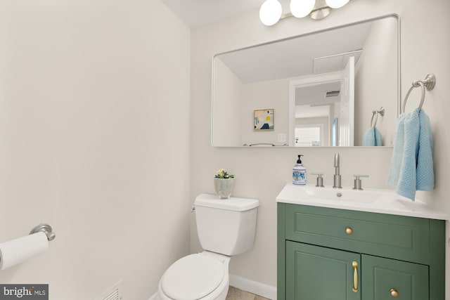 half bath with vanity, baseboards, and toilet