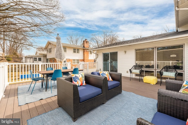 deck with an outdoor hangout area, a storage unit, an outbuilding, and outdoor dining area