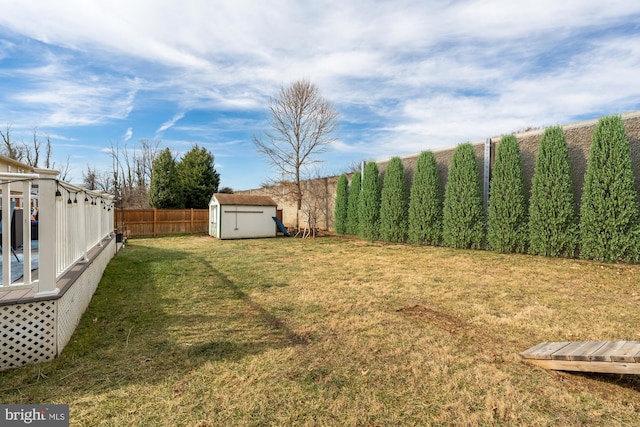 view of yard featuring an outdoor structure, a fenced backyard, and a storage shed