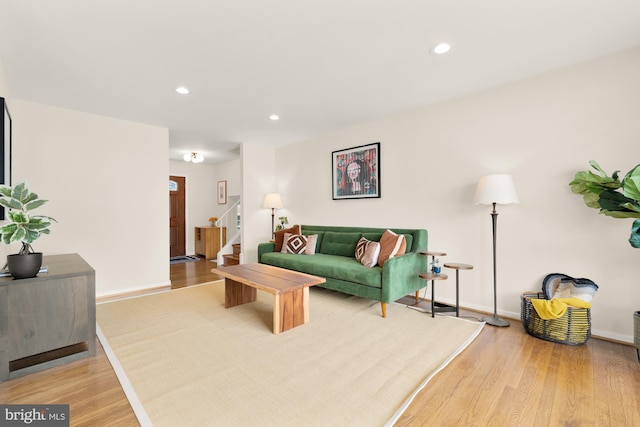living area featuring stairs, recessed lighting, baseboards, and light wood-type flooring