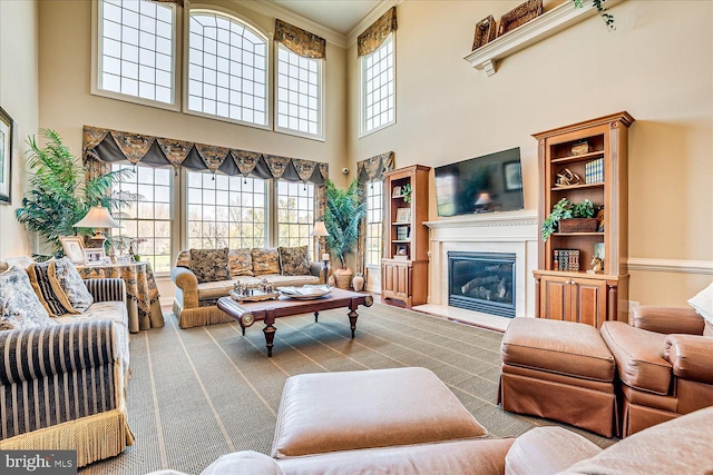 6 Ridgeview Way, Allentown, NJ 08501 - carpeted living room featuring crown molding, a glass covered fireplace, and a towering ceiling