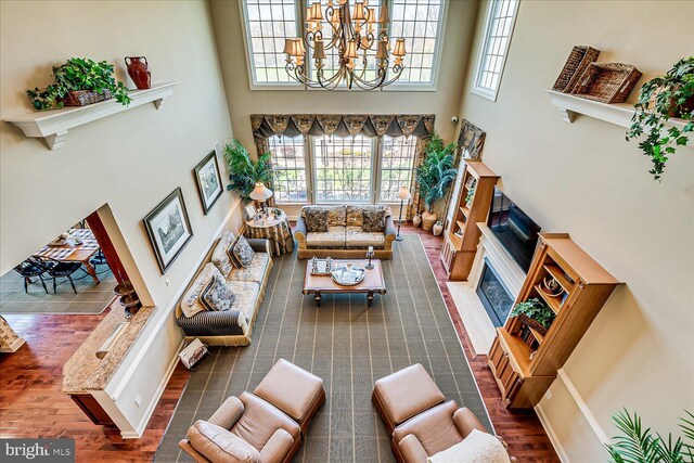 6 Ridgeview Way, Allentown, NJ 08501 - living area with a fireplace with flush hearth, wood finished floors, a towering ceiling, and an inviting chandelier
