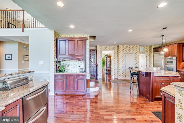 6 Ridgeview Way, Allentown, NJ 08501 - kitchen with light wood-style flooring, visible vents, wallpapered walls, appliances with stainless steel finishes, and a breakfast bar area