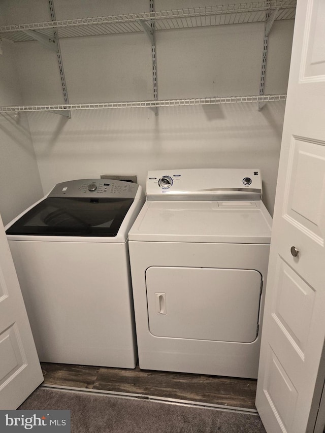 washroom featuring laundry area, washer and clothes dryer, and dark wood-style floors