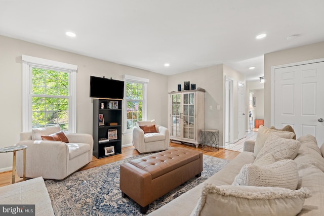 living room featuring healthy amount of natural light, wood finished floors, recessed lighting, and baseboards