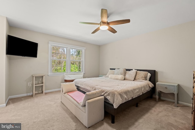 bedroom with light colored carpet, baseboards, and a ceiling fan