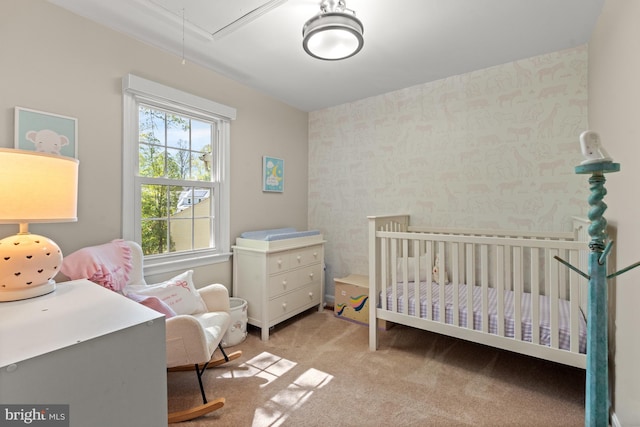 bedroom with attic access, light carpet, wallpapered walls, and a crib