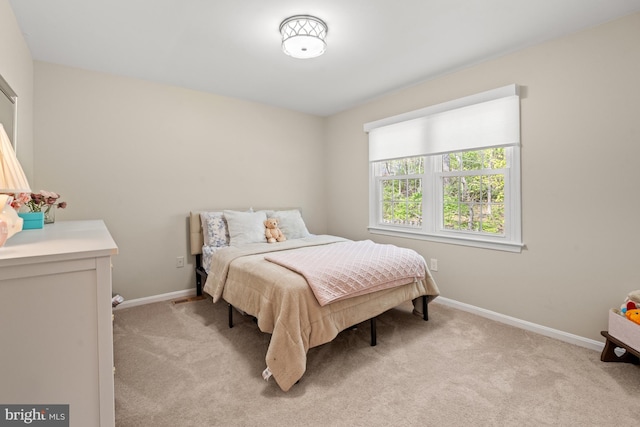 bedroom featuring light carpet and baseboards