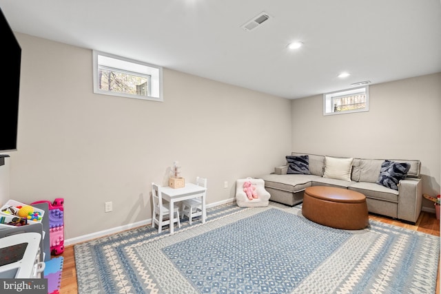 living area featuring wood finished floors, plenty of natural light, recessed lighting, and baseboards