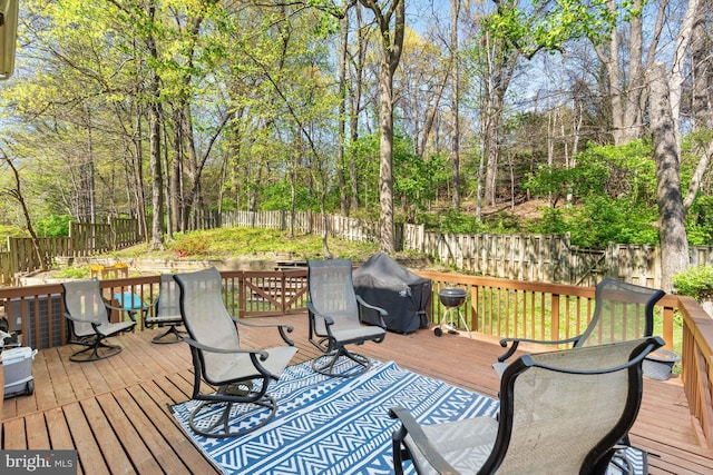 deck with a grill and a fenced backyard