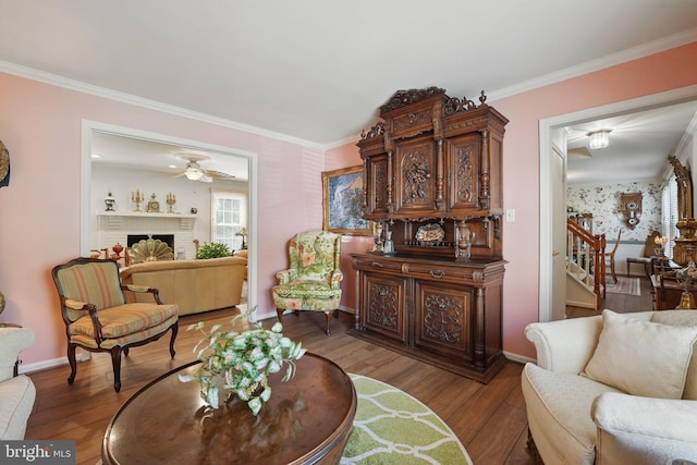 living room with crown molding, wood finished floors, and wallpapered walls