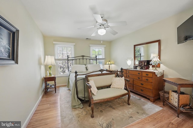 bedroom featuring light wood-style floors, visible vents, a ceiling fan, and baseboards