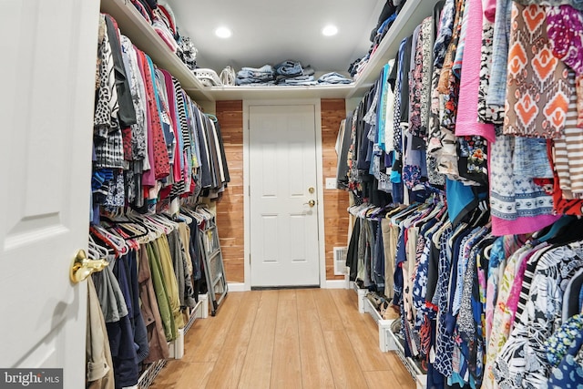 walk in closet featuring hardwood / wood-style floors and visible vents