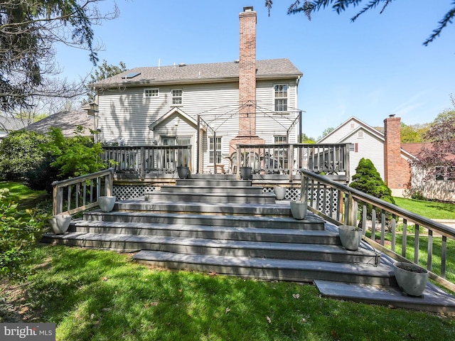 rear view of house featuring a chimney, stairs, and a deck