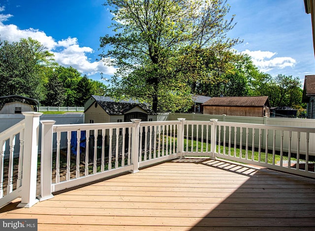 deck featuring a fenced backyard, an outdoor structure, and a shed