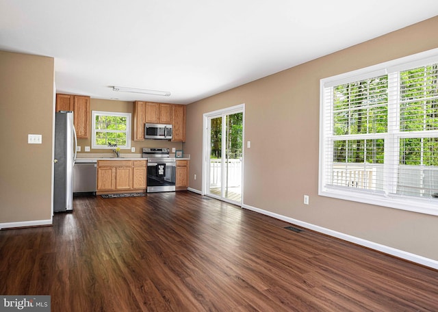 kitchen with light countertops, baseboards, stainless steel appliances, and a wealth of natural light