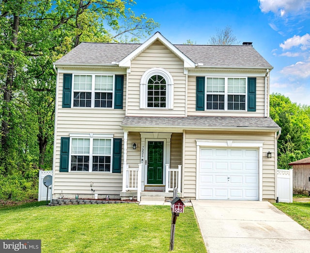 traditional-style house with roof with shingles, an attached garage, driveway, and a front lawn