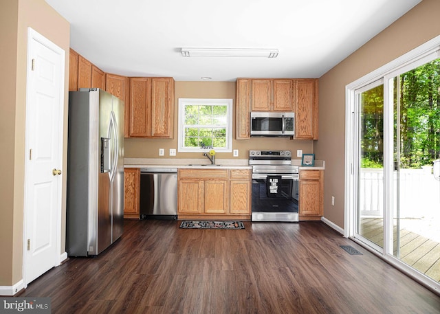 kitchen with visible vents, appliances with stainless steel finishes, dark wood finished floors, a sink, and light countertops