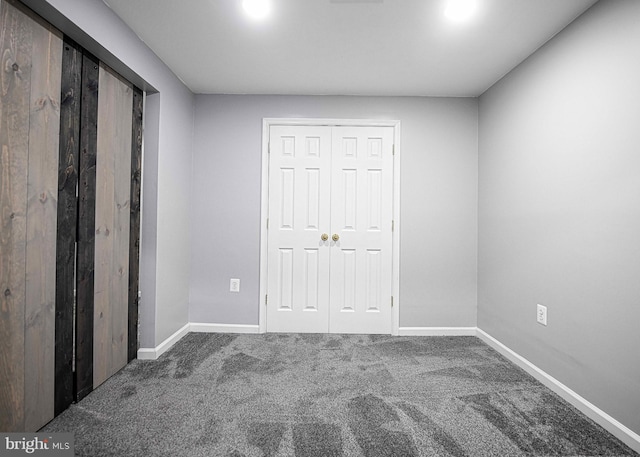 unfurnished bedroom with baseboards, carpet, and a closet