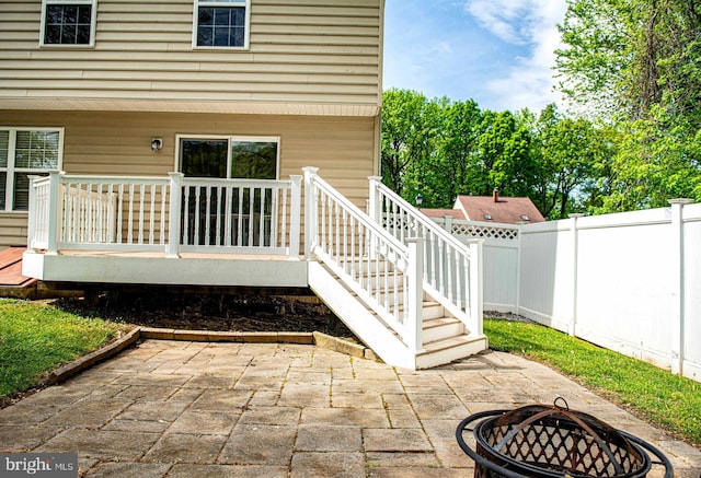 view of patio / terrace with a fenced backyard, stairway, an outdoor fire pit, and a deck