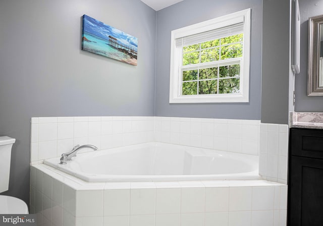 bathroom featuring vanity, toilet, and a bath