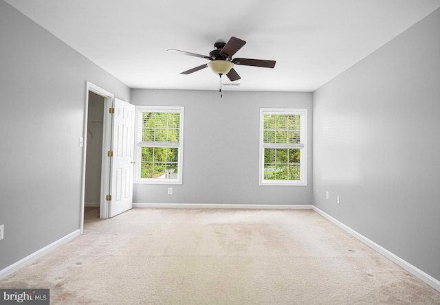 unfurnished room featuring ceiling fan, plenty of natural light, and baseboards