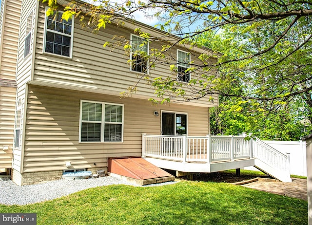 rear view of house with a lawn, a deck, and crawl space
